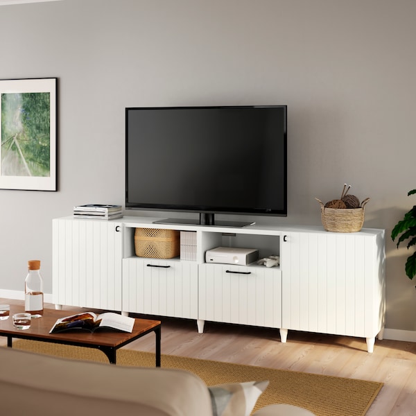 A black TV stands on a white BESTÅ TV bench with white KABBARP legs and white SUTTERVIKEN door/drawer fronts.