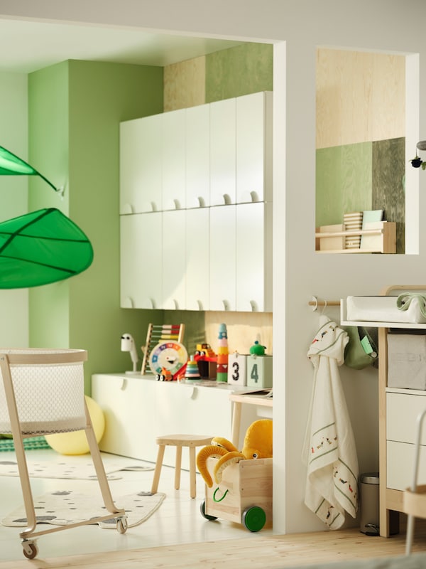 A children’s room with baby changing area shows a wall lined with SMÅSTAD cupboards and the edge of a LÖVA canopy.