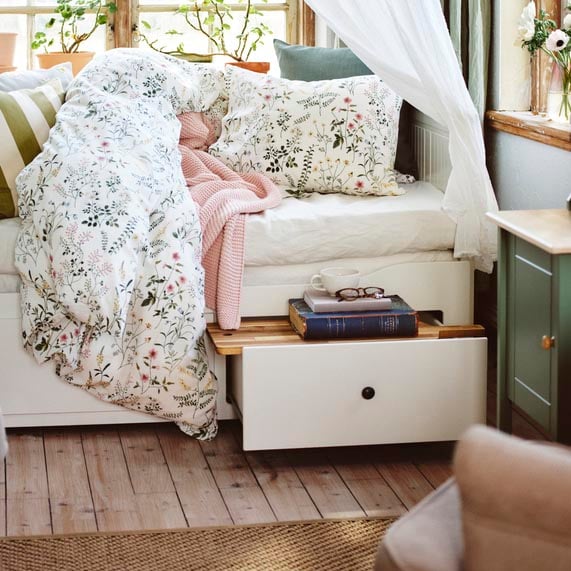 A HEMNES daybed with one of the drawers opened. 