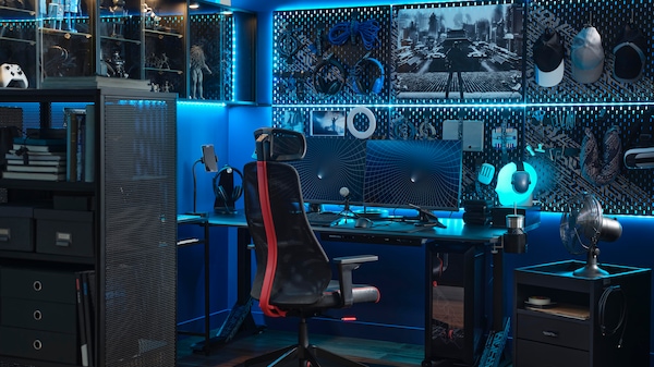 A high-tech gaming setup with blue LED lighting and two monitors on a desk with a black MATCHSPEL gaming chair in front.