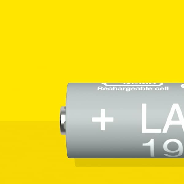 A LADDA rechargeable battery, HR06 AA, with a battery capacity of 1900mAh, is lying on a yellow surface.