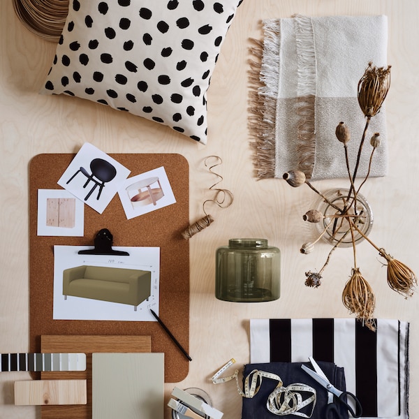 A moodboard with images of furniture laid out on a SUSIG cork deskpad beside a cushion, two glass vases and colour samples.