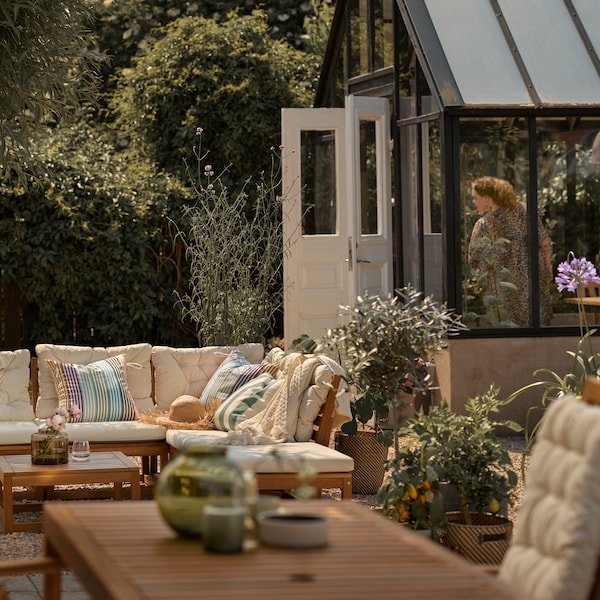 A patio with a light brown outdoor modular sofa with beige cushions, plus a light brown outdoor table with a reclining chair.