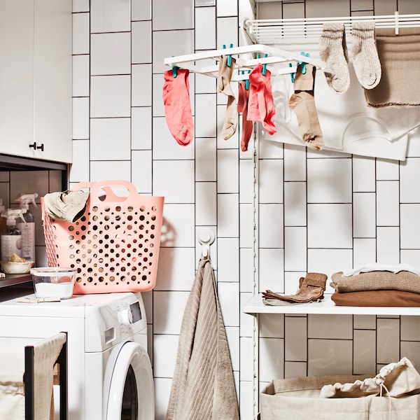 A washing machine and a storage combination for laundry with a cabinet, beside a laundry combination with a shelf.