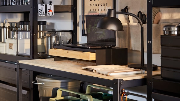 An IKEA BROR workbench in black and wood with a notebook and laptop on top