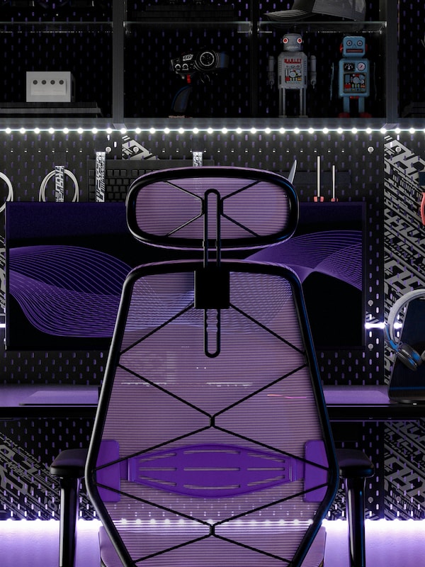 An IKEA STYRSPEL gaming chair in purple and black in front of a black gaming desk.