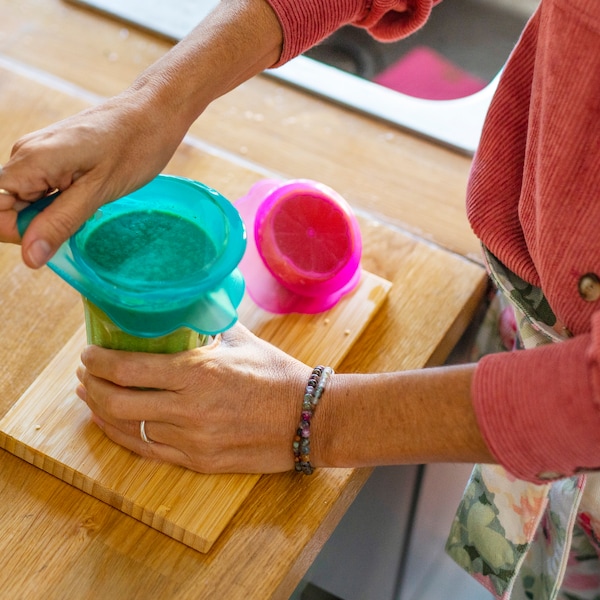 A person using ÖVERMÄTT covers over containers.