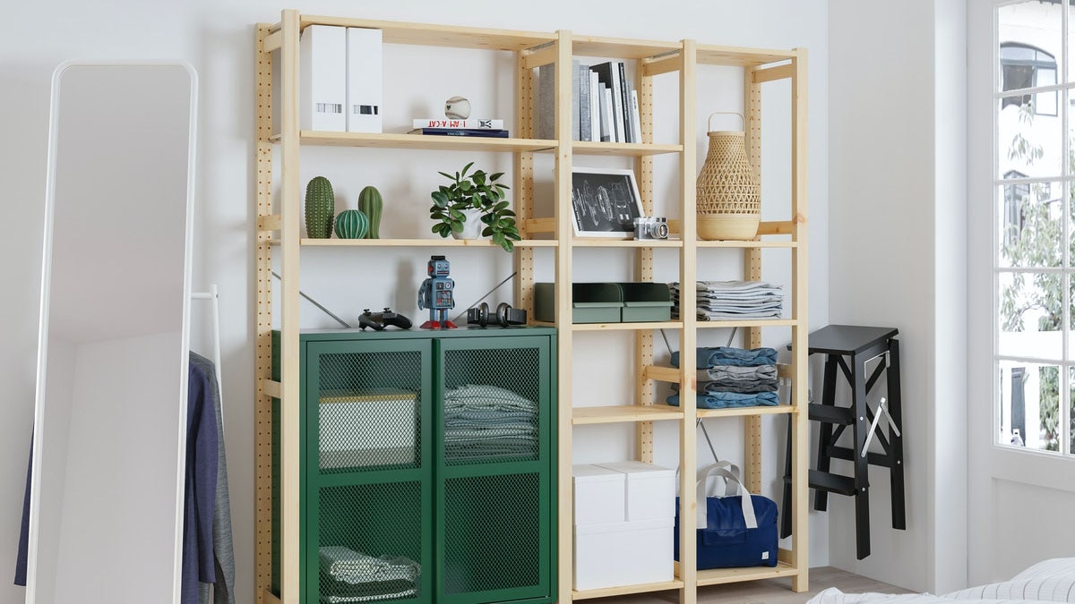 IVAR storage unit in a living room, with a mirror, stool and sofa bed.  