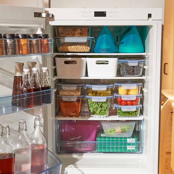 IKEA food containers and boxes organised in an open fridge.
