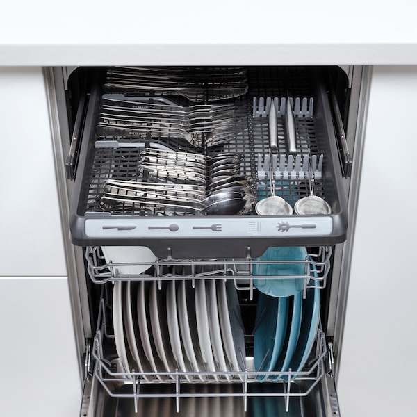 A MEDELSTOR dishwasher open to show the modern interiors with some mugs and plates.