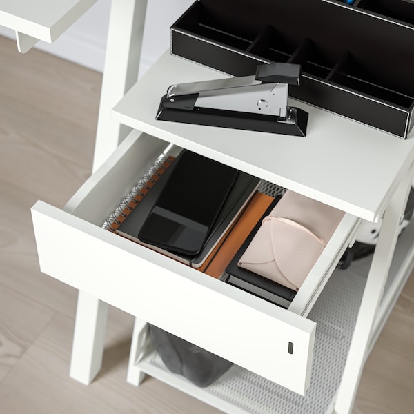 A TROTTEN office drawer unit in white with the drawer open filled with various office supplies and a phone.
