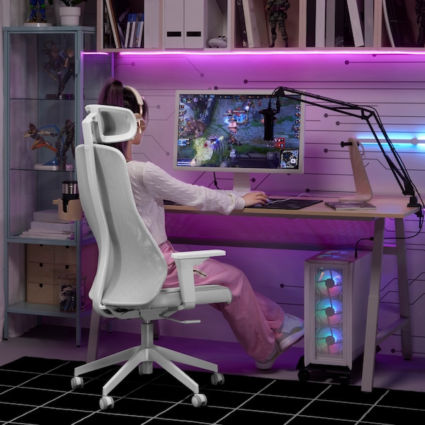 A person playing video games on a desk, sitting on an IKEA MATCHSPEL gaming chair, all lit with purple  neon lights.