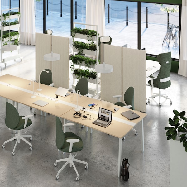 An office set up with IKEA MITTZON furniture, desks and green office chairs.