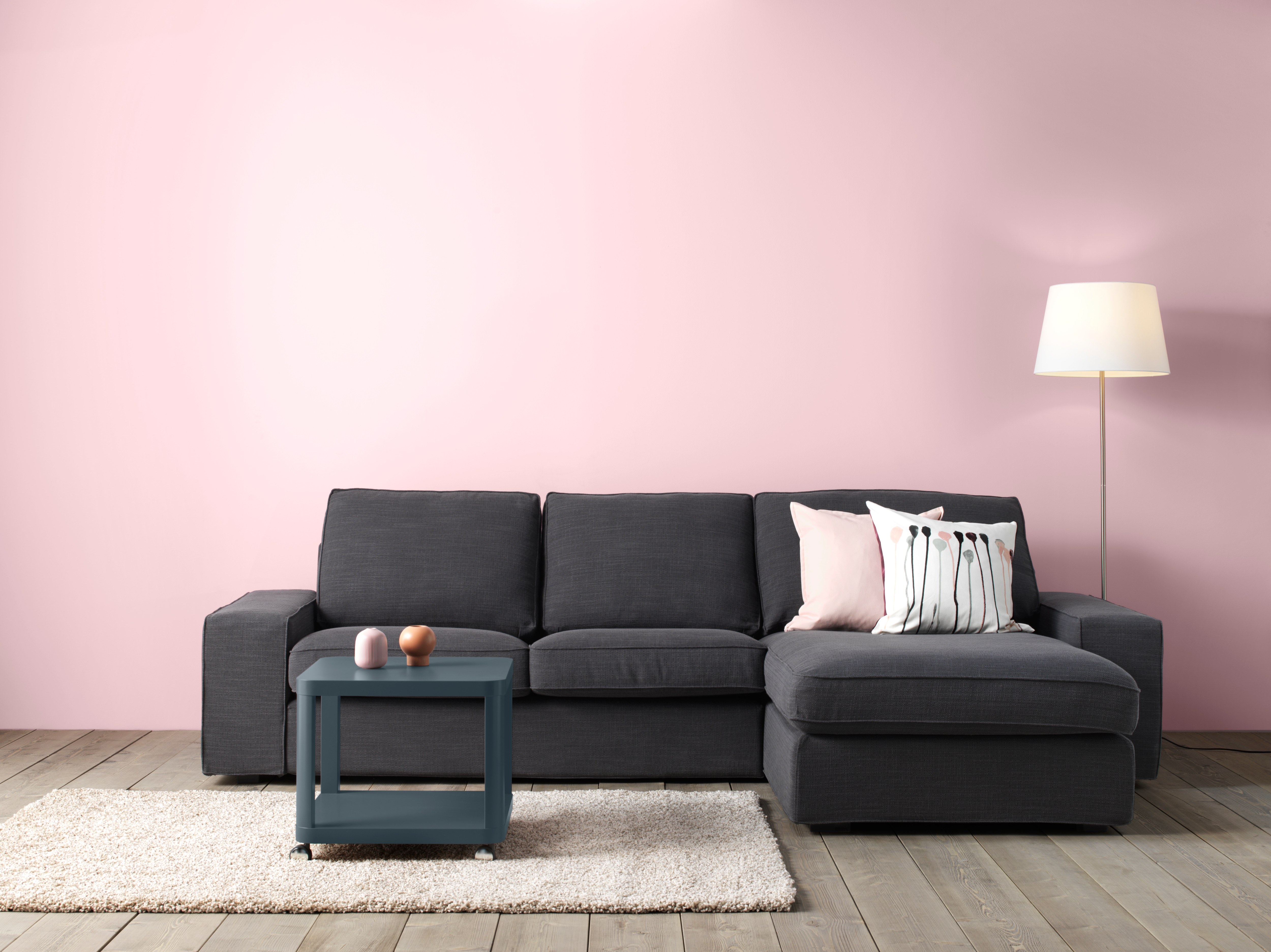 KIVIK corner sofa in dark grey next to lamp and in front of pink wall