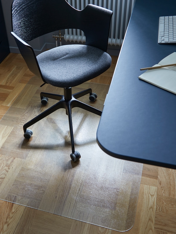 An IKEA KOLON office floor protector under a black desk chair