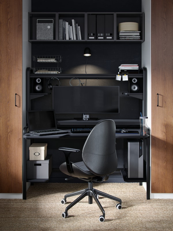 An IKEA FREDDE gaming desk with a matching black desk chair.