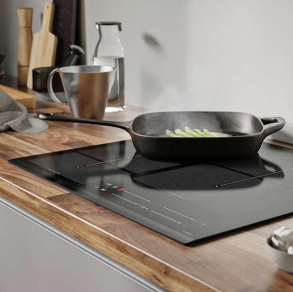 HÖGKLASSIG induction hob with a VARDAGEN iron pan on top.