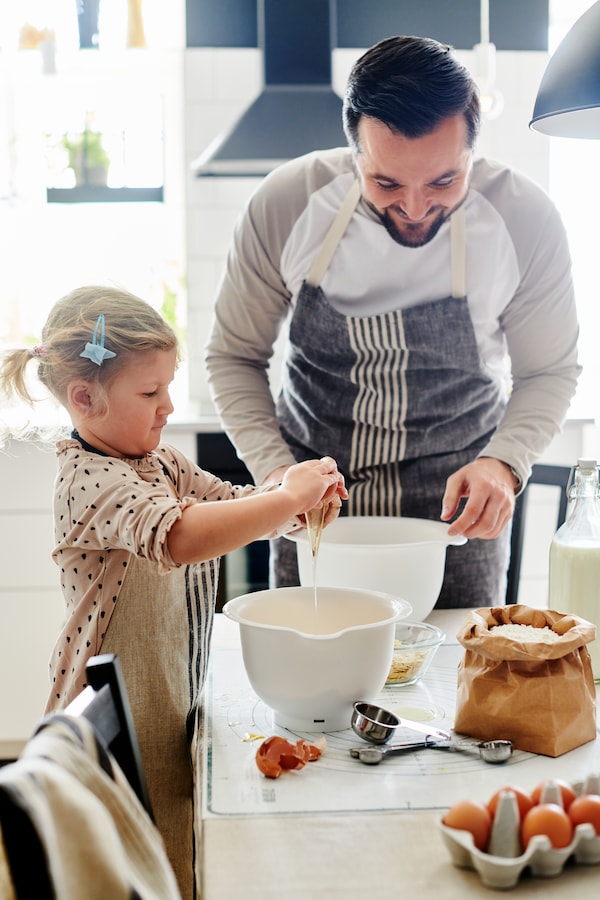 A dad and his daughter baking with IKEA VISPAD mixing bowls