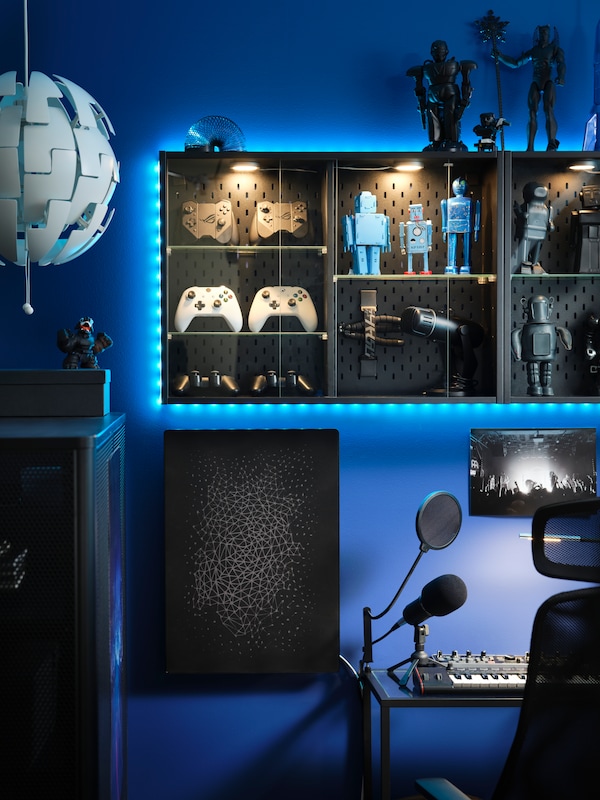 An IKEA UPPSPEL cabinets attached to a wall with gaming accessories and displaying figures.
