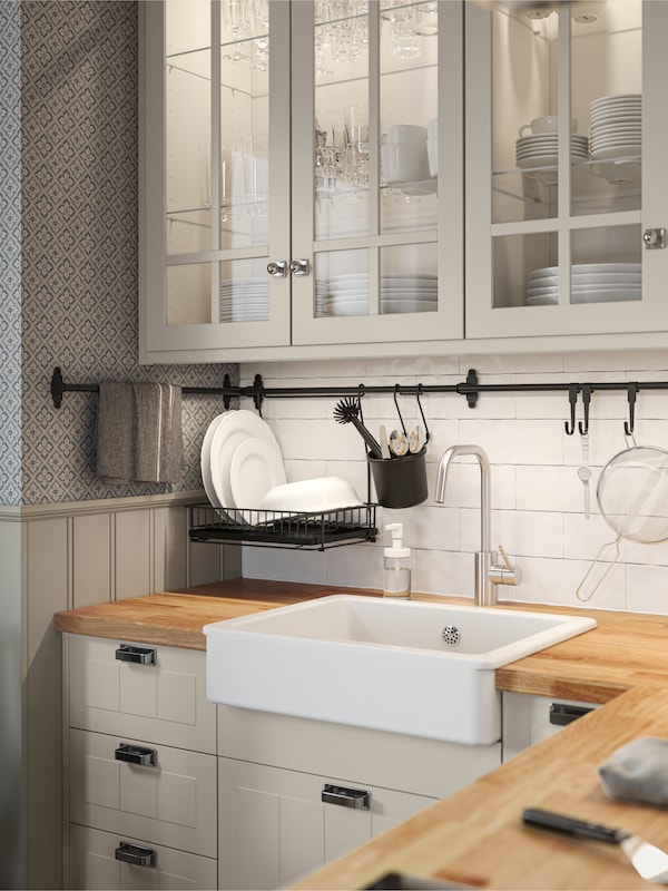 traditional kitchen with frames door with a white ceramic sink and a silver tap.