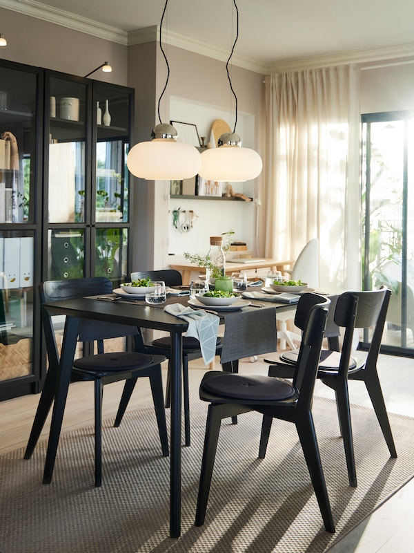 A LISABO dining table in black colour with four matching dining chairs