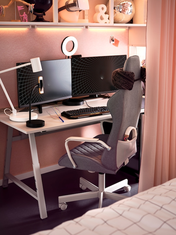 A pastel room with a gaming corner centred around a light-grey UTESPELARE gaming desk and a grey UTESPELARE gaming chair.