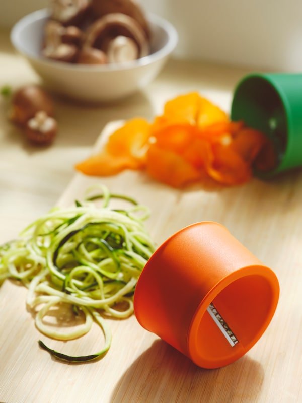 IKEA UPPFYLLD in orange and green vegetable slicers with sliced courgette on the side.