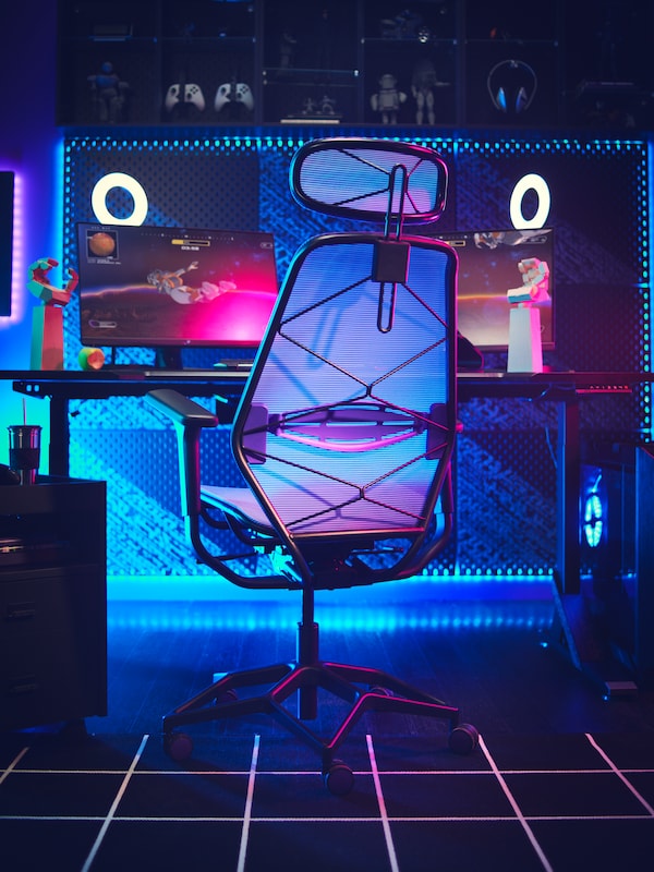An IKEA STYRSPEL chair from the back against a gaming desk with blue accent lighting. 