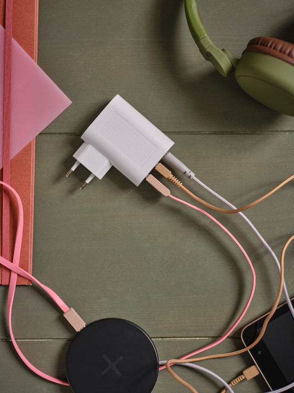 An IKEA SMÅHAGEL 3-port USB charger white with coloured USB cables plugged in.