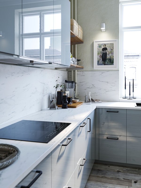 Double sided white marble effect/terrazzo effect LYSEKIL wall panels in a kitchen with light grey-blue fronts.