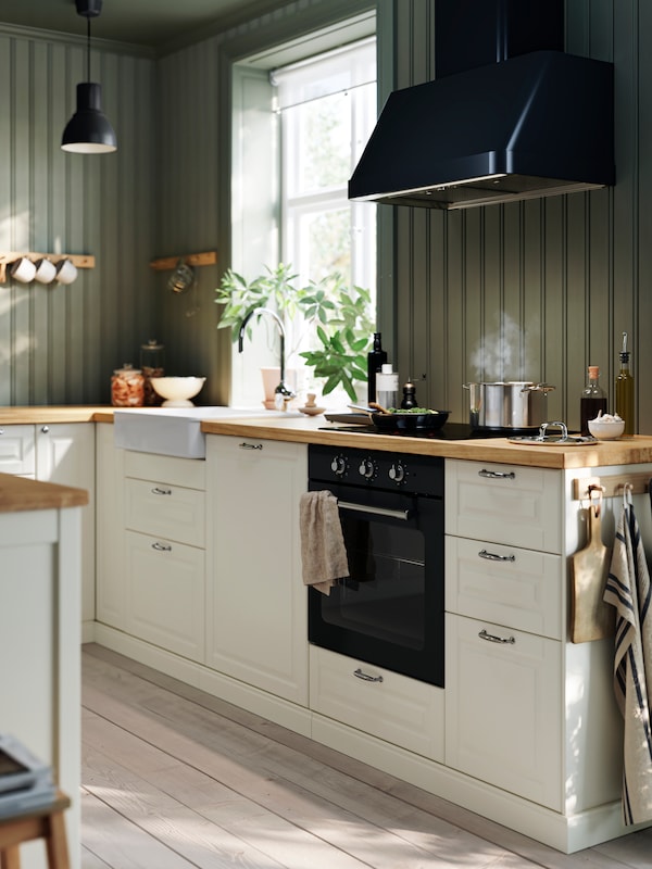 A traditional kitchen with a black traditional MATTRADITION oven and black extractor fan.