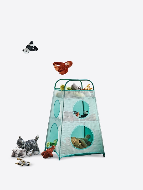 Soft toys are flying towards a turquoise TIGERFINK storage with soft toys stored inside and on the floor beside it.