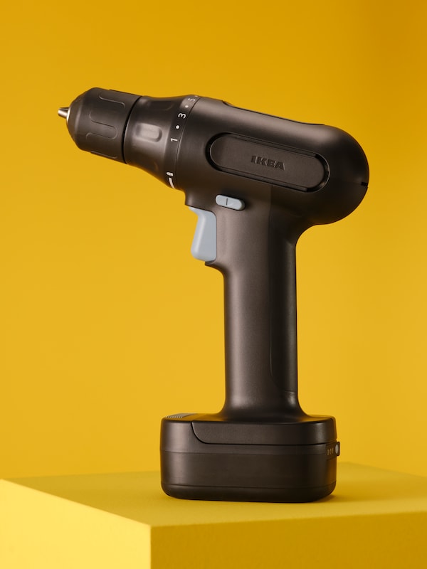 A TRIXIG screwdriver/drill placed on a bright yellow pedestal.