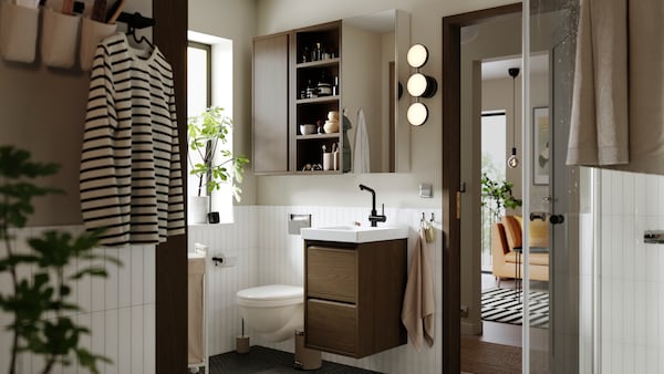 ÄNGSJÖN dark wood cabinet with 2 drawers in a bright modern bathroom.