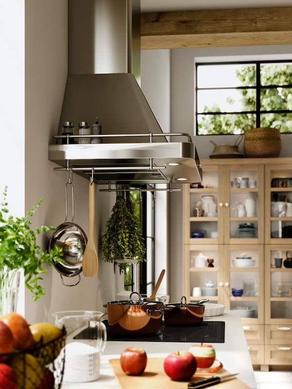 A traditional kitchen focuses on the HÖGKLASSIG induction hob and FÖLJANDE  stainless steel extractor.