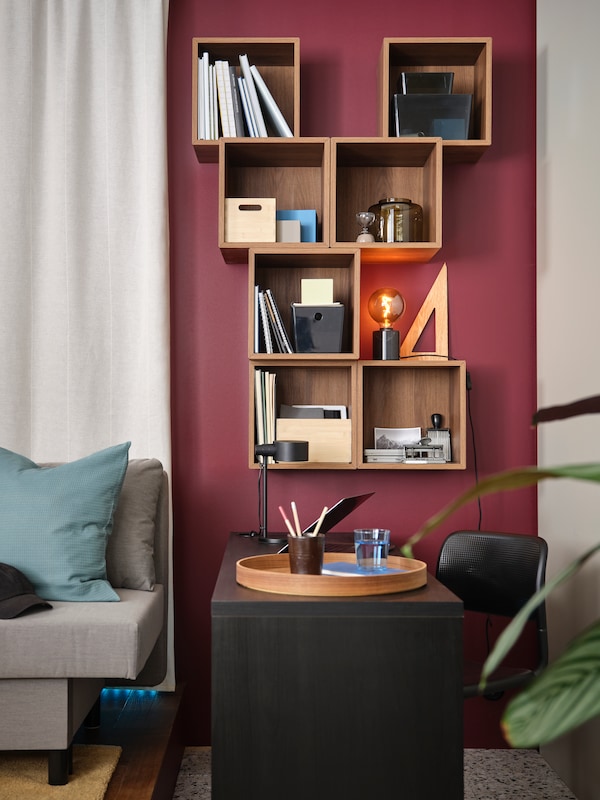 Multiple EKET cube storage in brown walnut effect are mounted in a living room. 