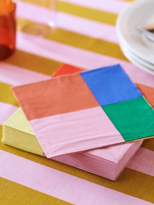 An IKEA TESAMMANS napkin in various colours over a matching pink and yellow tablecloth.