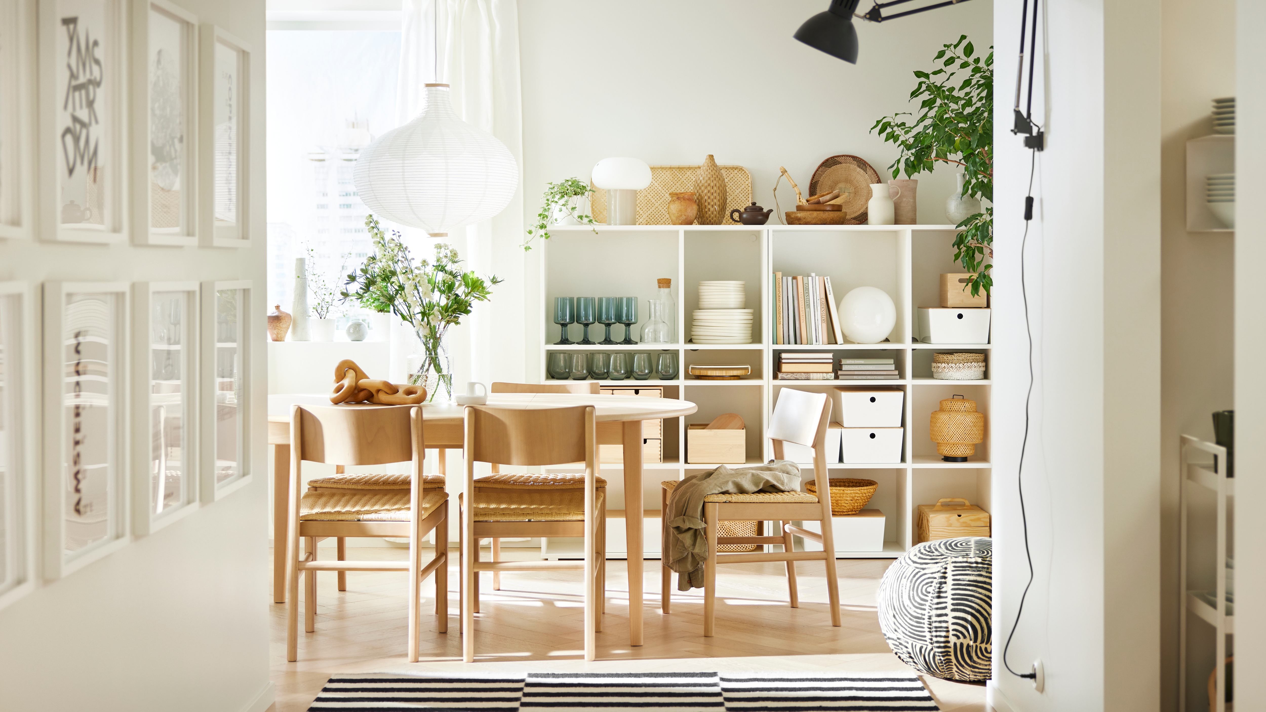 A SKANSNÄS round extendable table and four SKANSNÄS light beech chairs stand under a white RISBYN pendant lamp.