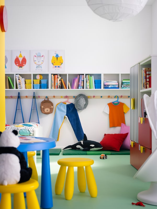 Some in/outdoor MAMMUT children’s furniture stands in a children’s room with three SMÅGÖRA shelf units on the wall.